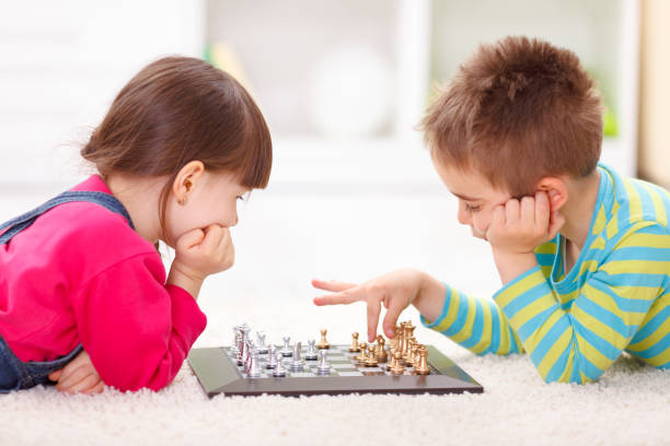 istock Little girl and boy playing chess 964786016