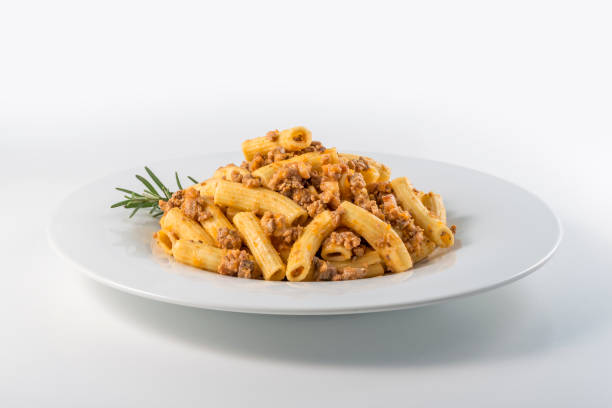 Plate of macaroni pasta with Bolognese ragù Round white Plate of macaroni pasta with Bolognese ragù rigatoni stock pictures, royalty-free photos & images