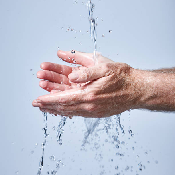istock Mature man rinses hands under running water 964789980