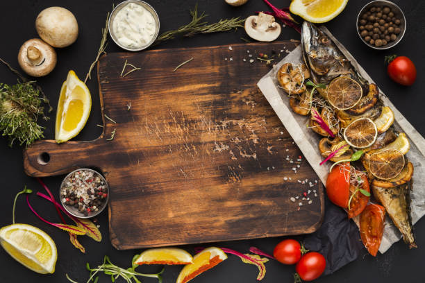 istock Grilled fish, cooking ingredients on wooden cutting board, top view 964790076