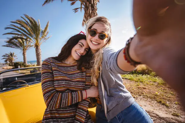 Photo of Young hipster women taking selfies on summer holidays road trip