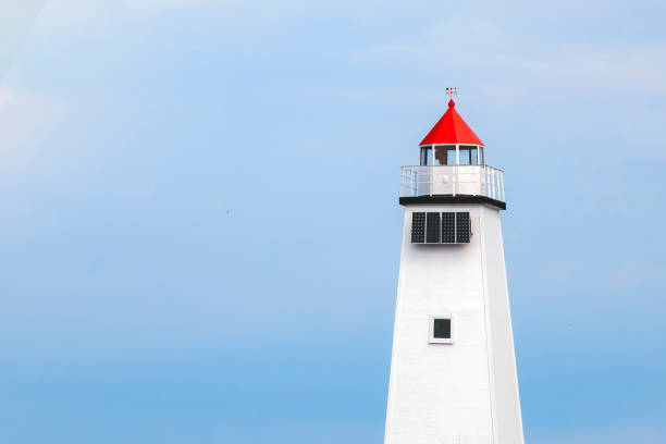 istock White lighthouse with a red roof against the sky. 964794032