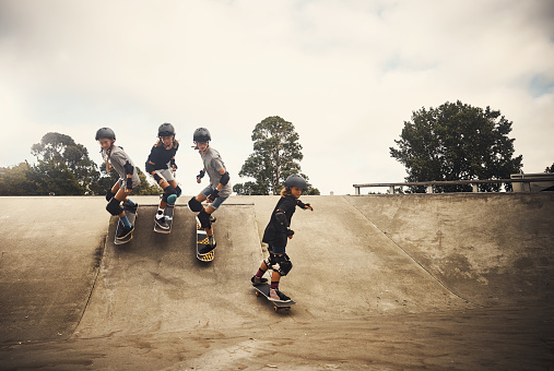 Shot of a group of young girls skateboarding together at a skatepark