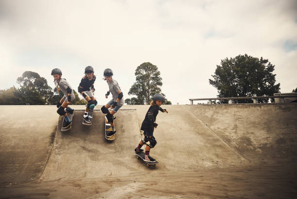 Life is all about moving forward Shot of a group of young girls skateboarding together at a skatepark skateboarding stock pictures, royalty-free photos & images