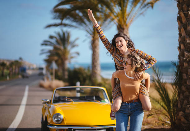 istock Young women on road trip having fun with piggyback ride 964805490