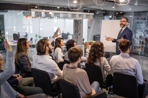 ceo feliz dando a su equipo una presentación de negocios en una sala de juntas. - seminar asking business meeting fotografías e imágenes de stock