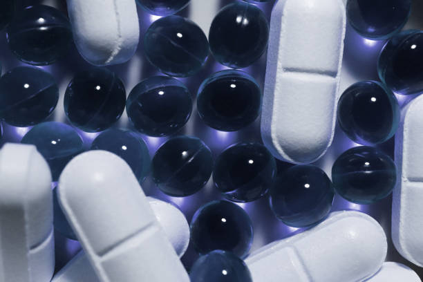 istock White Medicine Tablets with Blue Capsules. Pharmacy Pills Background. Macro Closeup. Top View. 964808520