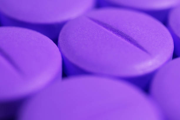 compresse di medicina viola. sfondo pillole farmacia. primo piano macro. - pill purple capsule vitamin pill foto e immagini stock