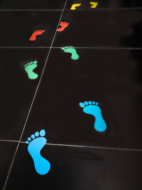 istock Colorful Footprints in black floor. 964813568