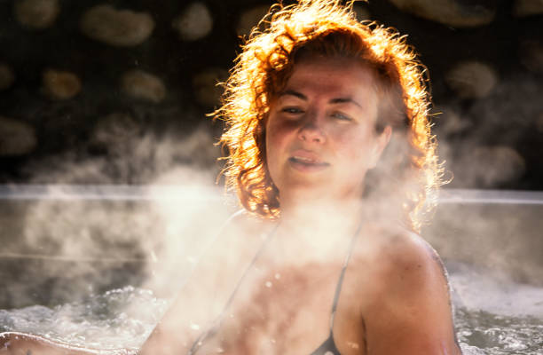 istock Woman sits in a steaming hot tub 964816052