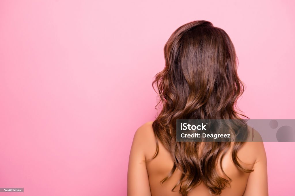 Portrait with copy space, rear view of young, sexy, pretty, attractive, naked, shirtless girl with curly, perfect, ideal hair, isolated on pink background Hair Stock Photo