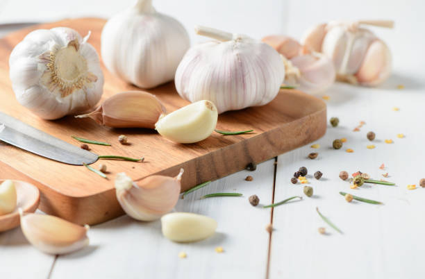 istock Garlic on wood block and white wood 964821560