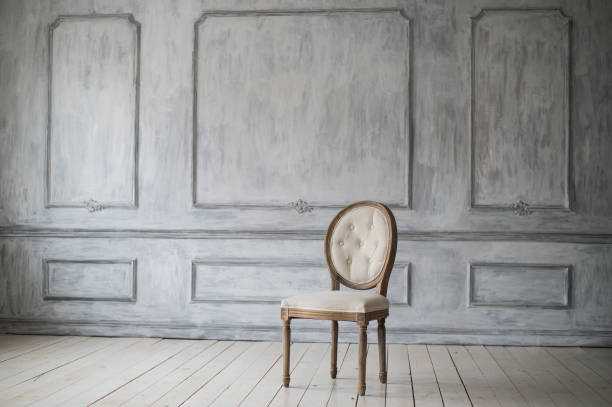 istock Antique white chair over luxury light wall design bas-relief stucco mouldings roccoco elements 964824328