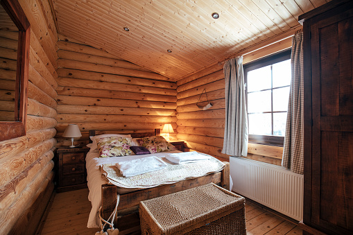 Photograph of a bedroom in a log cabin.