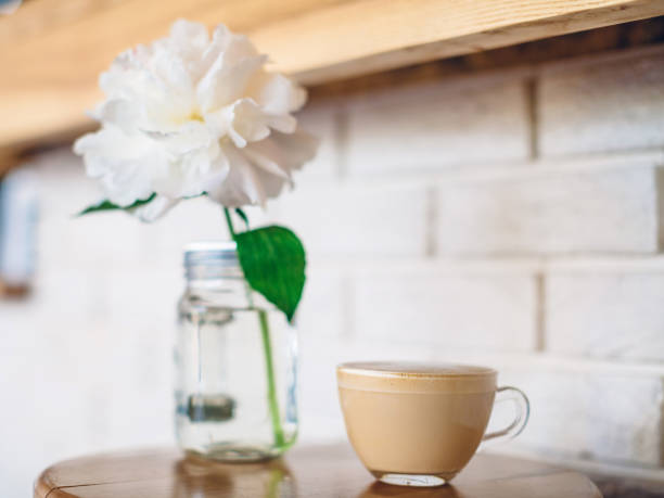 istock A cup of cappuccino in a cafe on white brick wall background 964825186