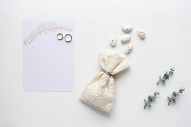 istock Wedding invitation card, candy, rings and oregano branches. Top view. 964825240