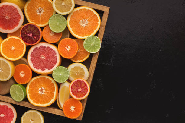 istock Variety of ripe citruses on black background 964827688