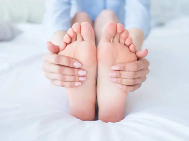 Photo of Closeup woman hands doing foot massage