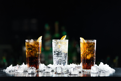 Dos whisky y Coca-Cola cócteles y una bebida alcohólica blanca en la barra de tabla. photo
