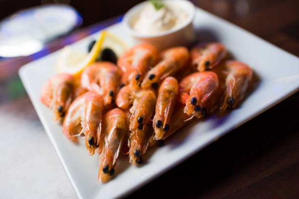 istock Appetizer of boiled shrimp on a white plate with white sauce 964829934