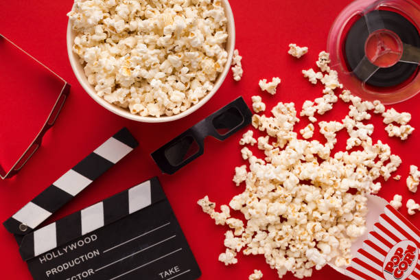 istock Clapperboard, 3D glasses and popcorn on red background 964838296