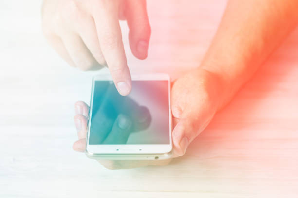 istock Man using smartphone a touch screen smart phone hands close up Light toning 964838592