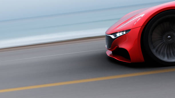 istock red car driving on a road by sea 964842974