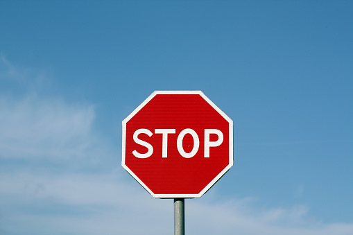 Stop sign against cloudy sky. Abstract background and texture for design.