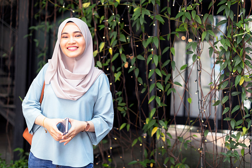 Portrait of a cheerful Malaysian girl wearing hijab attending a social