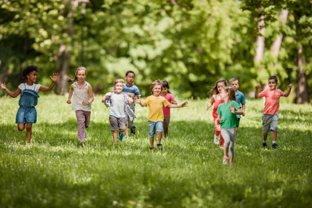 istock Carefree children having fun while running in spring day at the park. 964843362