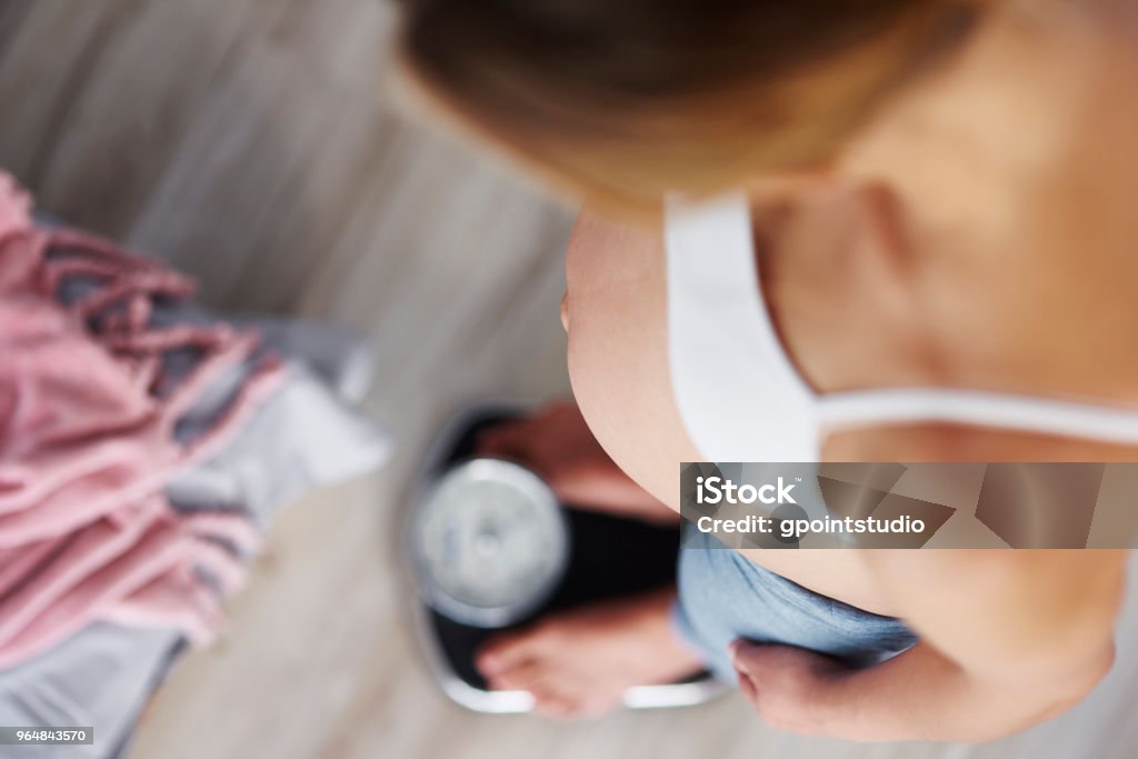 High angle view of pregnant woman standing on scale Pregnant Stock Photo