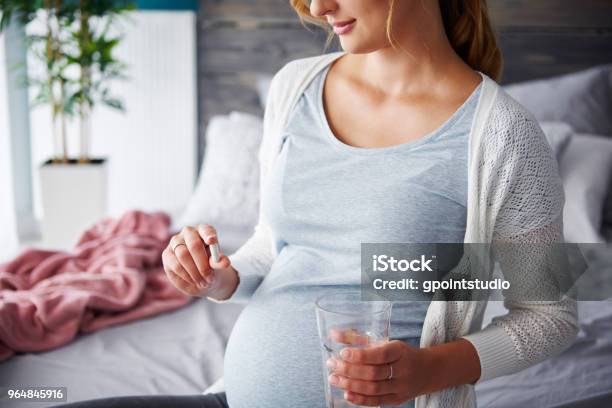 Young Pregnant Woman Taking Capsule Stock Photo - Download Image Now - Pregnant, Folic Acid, Women