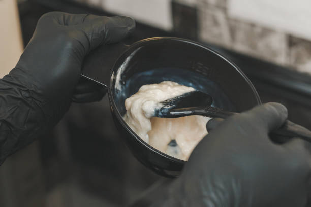 istock Hair stylist hands preparing a dye in a container 964847724