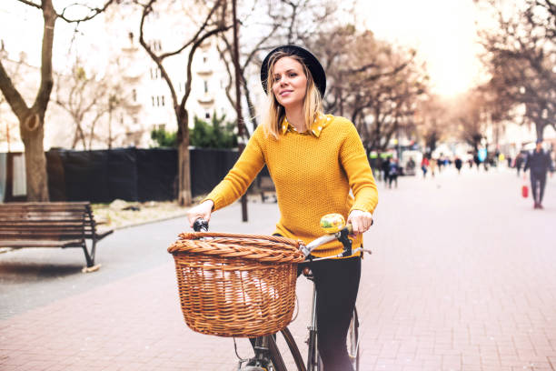 istock Young woman riding a bicycle in sunny spring town. 964850572