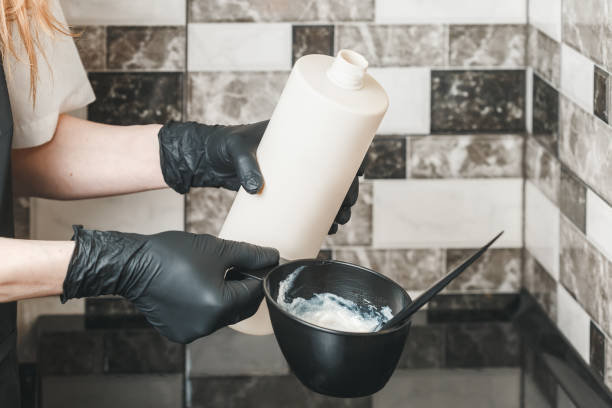 istock Hair stylist hands preparing a dye in a container 964850962