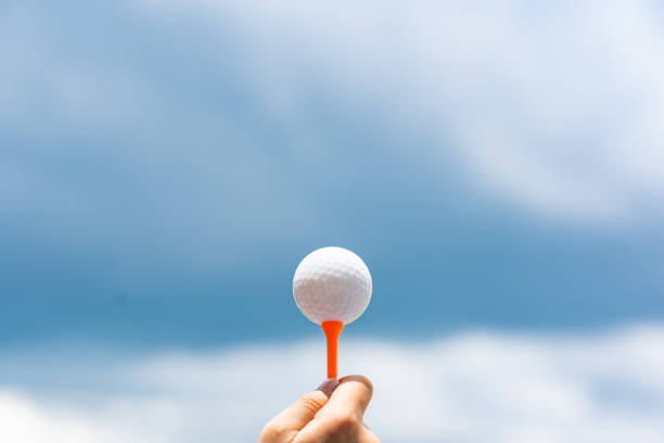 istock Golf ball on tee on sky blue and cloud background 964854042