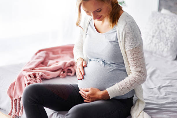 istock Cheerful pregnant woman touching her stomach 964854552
