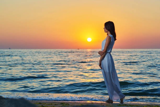 istock Beatiful girl walking alone on sandy beach on sunset. 964867830