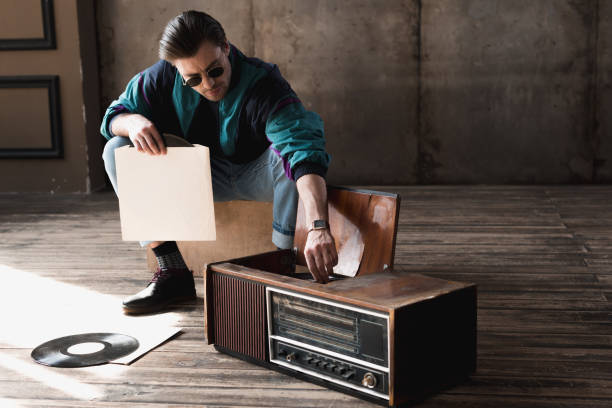 istock handsome nostalgic man in vintage windcheater with vinyl record player 964868434