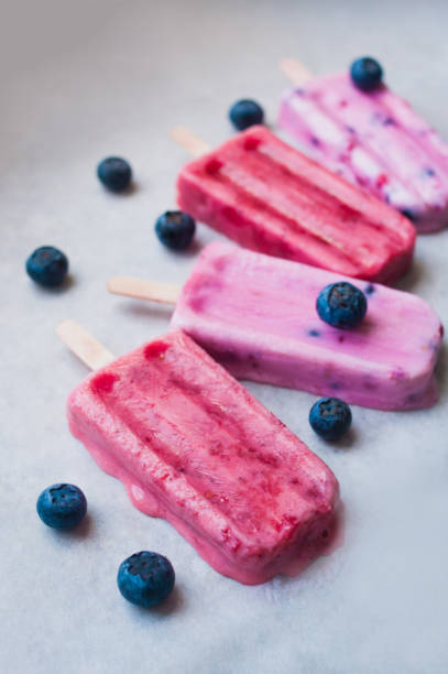 istock Pink and purple poscicles with blueberry 964875034