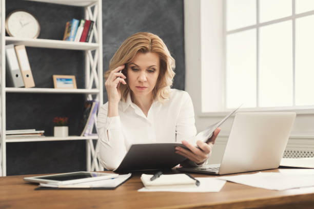 istock Thoughtful businesswoman reading document at office desktop 964876250