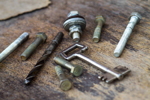 Metal hardware with carvings figures on a wooden background.