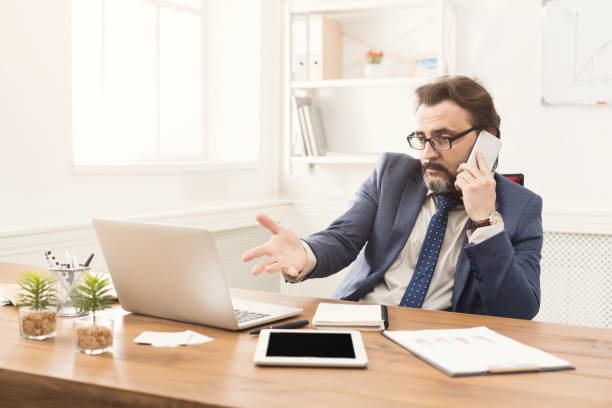 istock Serious businessman talking on mobile phone 964879636