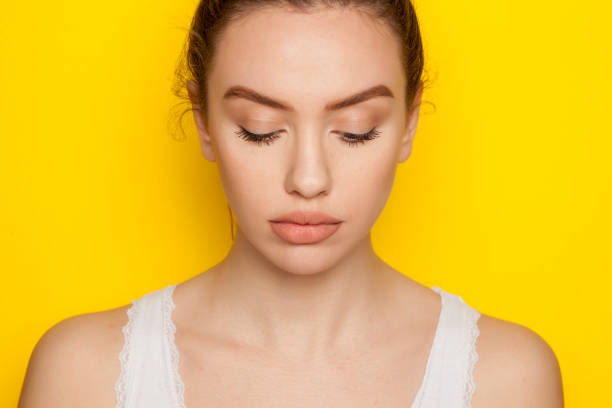 istock Beautiful young woman posing on yellow background 964880502