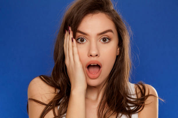 istock shocked young beautiful woman on blue background 964883902