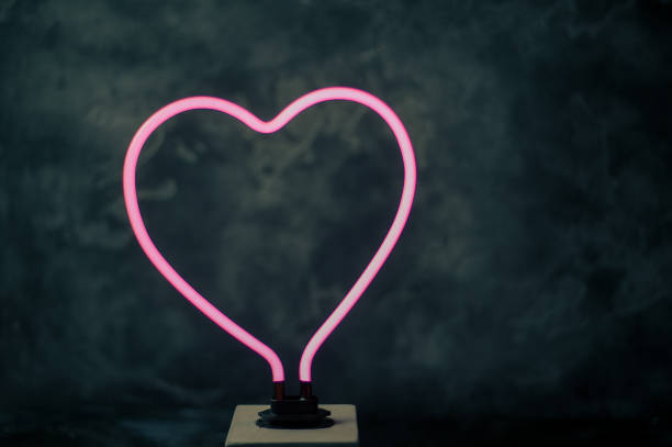 istock glowing neon heart shape with black textured back 964884708