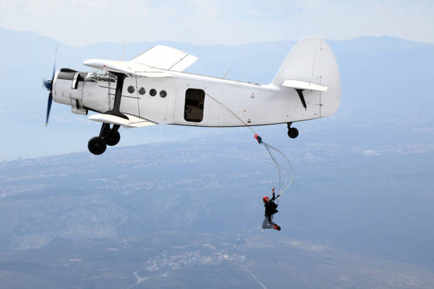 istock Parachutists jump from a vintage biplane 964887038