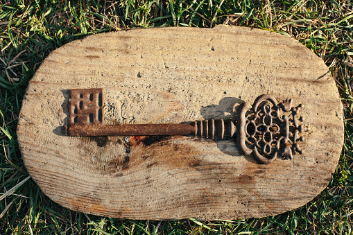 Antique vintage key on wooden stand in the grass