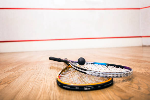 istock Squash racket and ball on the court close up 964895228