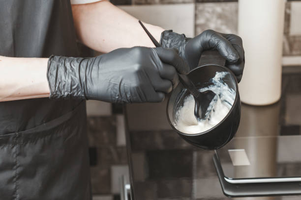 Hair stylist hands preparing a dye in a container Stylist preparing a hair dye in a container, hairdresser salon concept hydrogen peroxide stock pictures, royalty-free photos & images